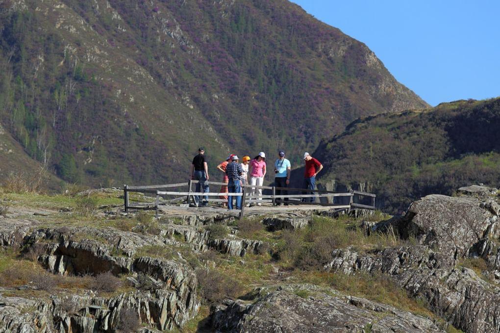 Туристы рассматриваю древние наскальные рисунки в Калбак-Таш