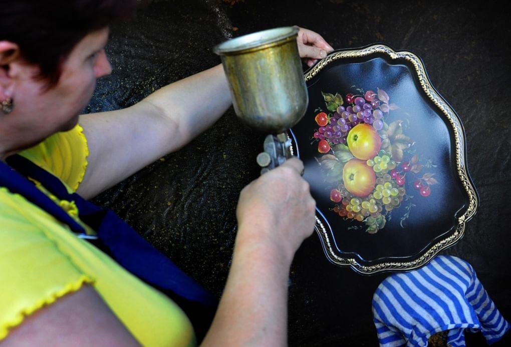 Покрытие подноса лаком на Жостовской фабрике декоративной росписи. Фотография: С. Красильников / ИТАР–ТАСС 