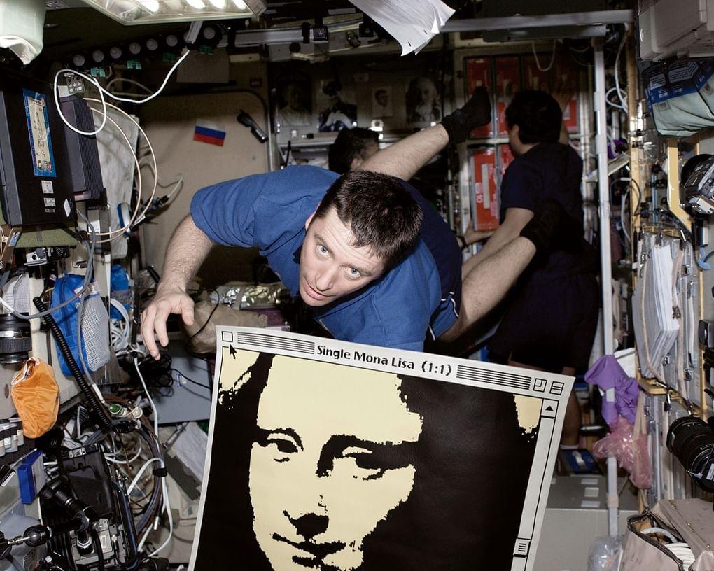 Итальянский астронавт Роберто Витори с картиной «Single Mona Lisa 1:1» в невесомости на борту Международной космической станции. Апрель 2005 года