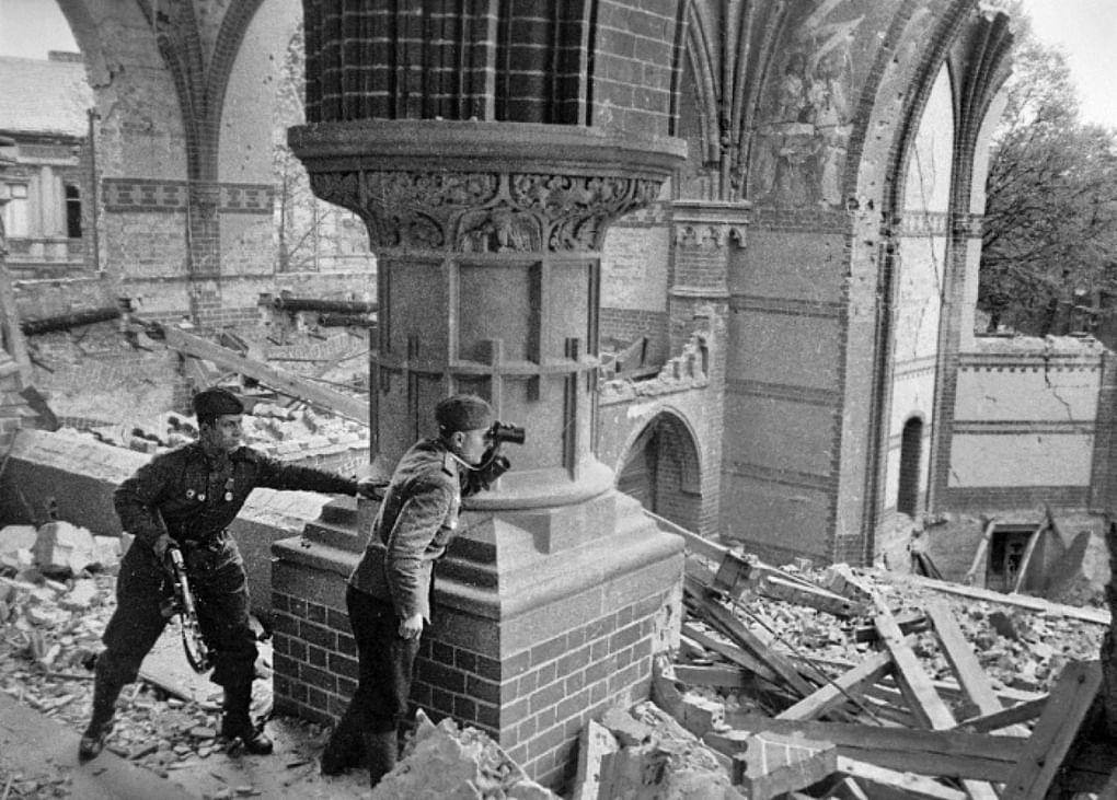 Советский офицер ведет корректировку артиллерийского огня на разрушенных улицах Берлина