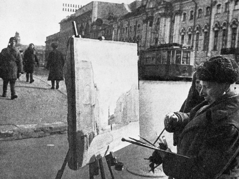 Художник Вячеслав Пакулин делает зарисовки на Невском проспекте. Ленинград, 1943 год. Фотография: <a href="https://artsacademy.ru/additionally/patrioticheskoe-vospitanie/akademiya-khudozhestv-v-gody-vov/" target="_blank" rel="noopener">artsacademy.ru</a>